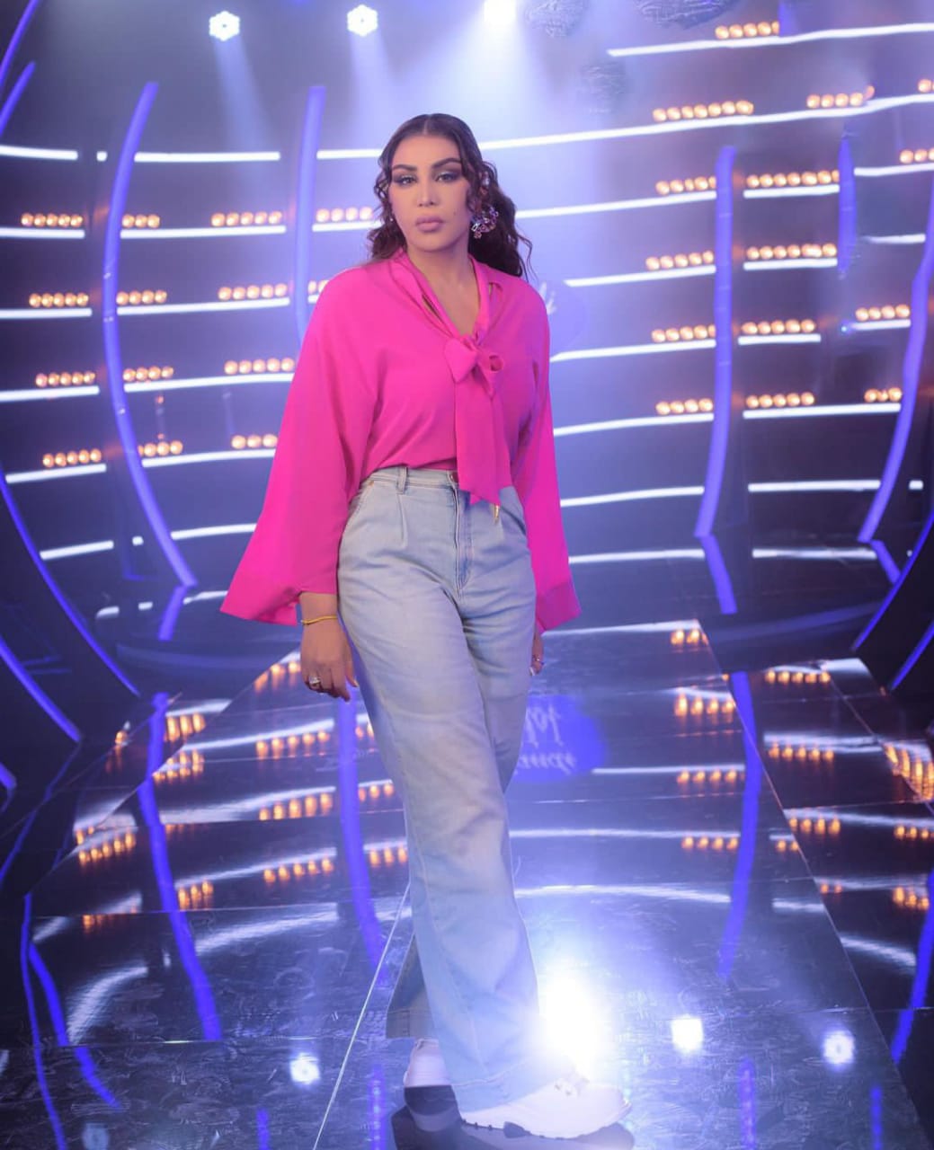 إطلالة بنطلون جينز مع بلوزة ناعمة بالفوشيا