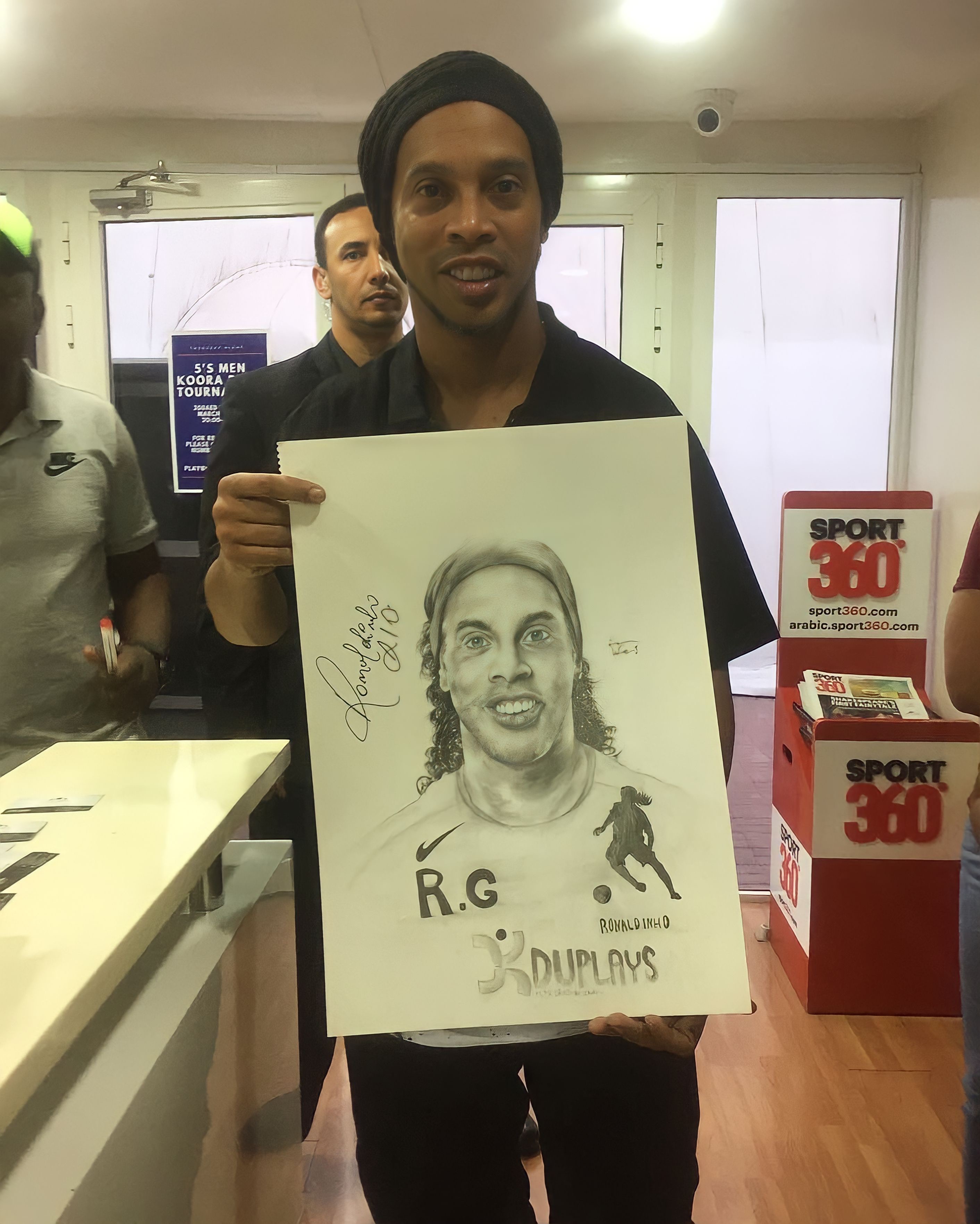  النجم البرازيلي رونالدينيهو يحمل بورتريه له بريشة المبدع طارق بلدينا