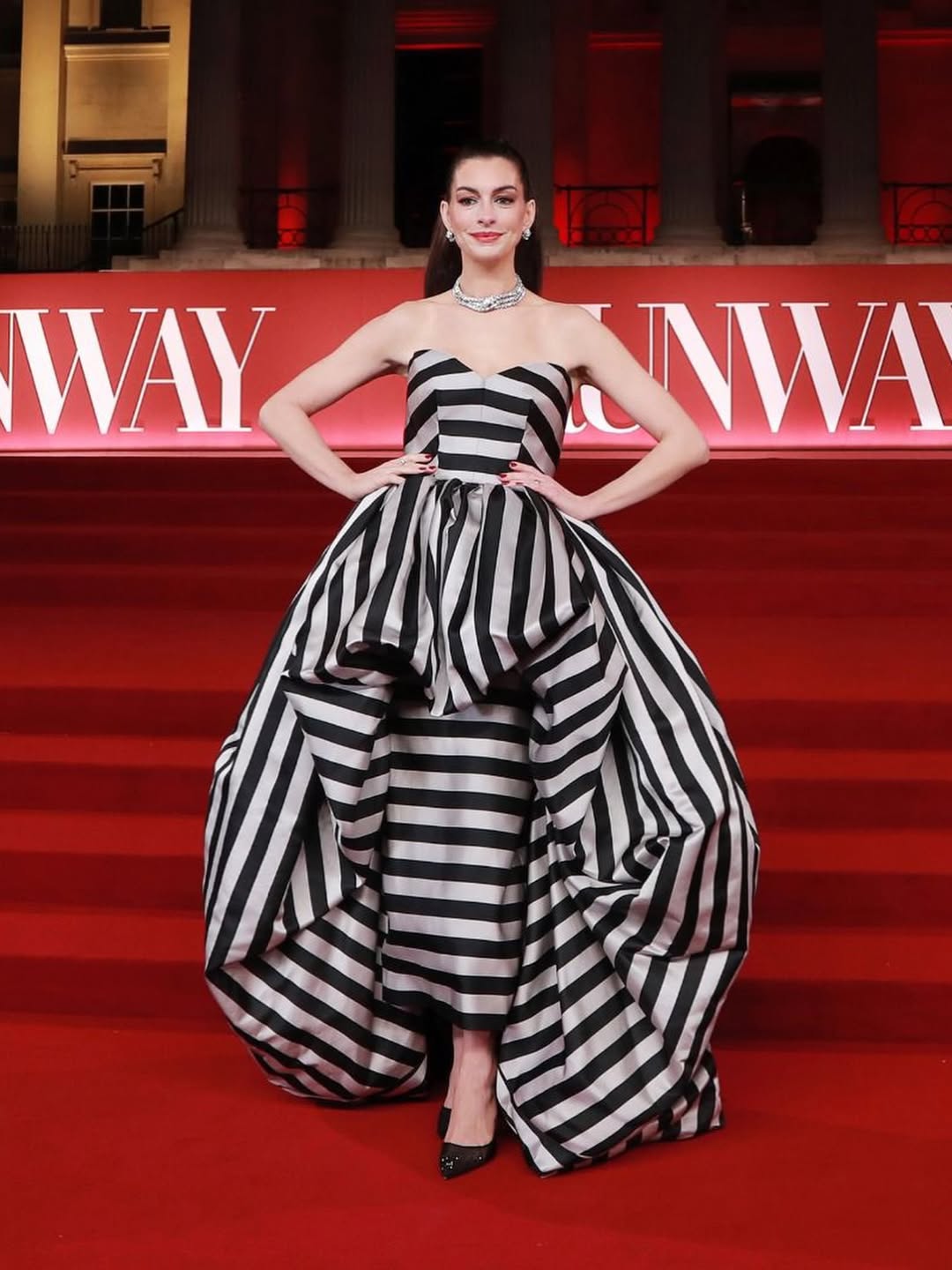 آن هاثاواي بفستان بنمط التقليمات من الشرائط العريضةعلى شكل كورسيه وتنورة بنسل