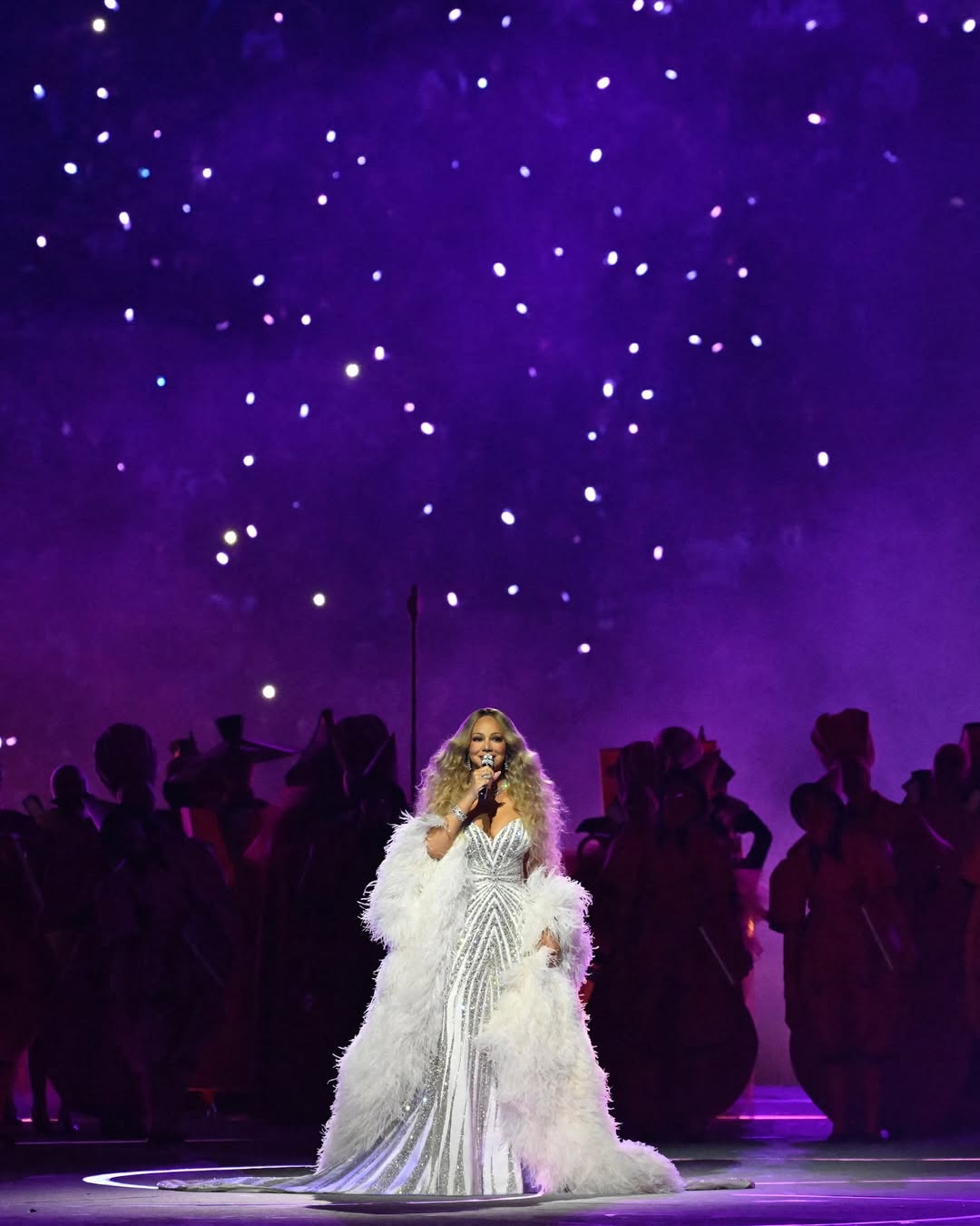 أرفق فستان ماريا كاري بوشاح دراماتيكي منتفخ من الريش الأبيض