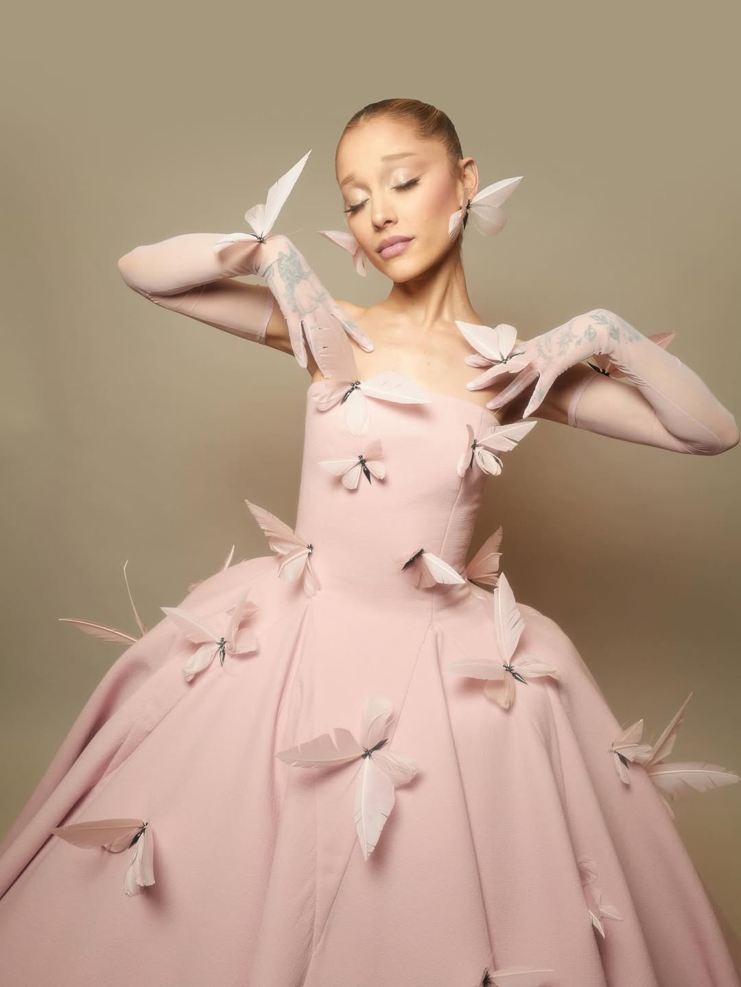 أريانا غراندي بفستان زهري بتصميم الأميرات بلمسة حالمة لفراشات مصنوعة من الريش