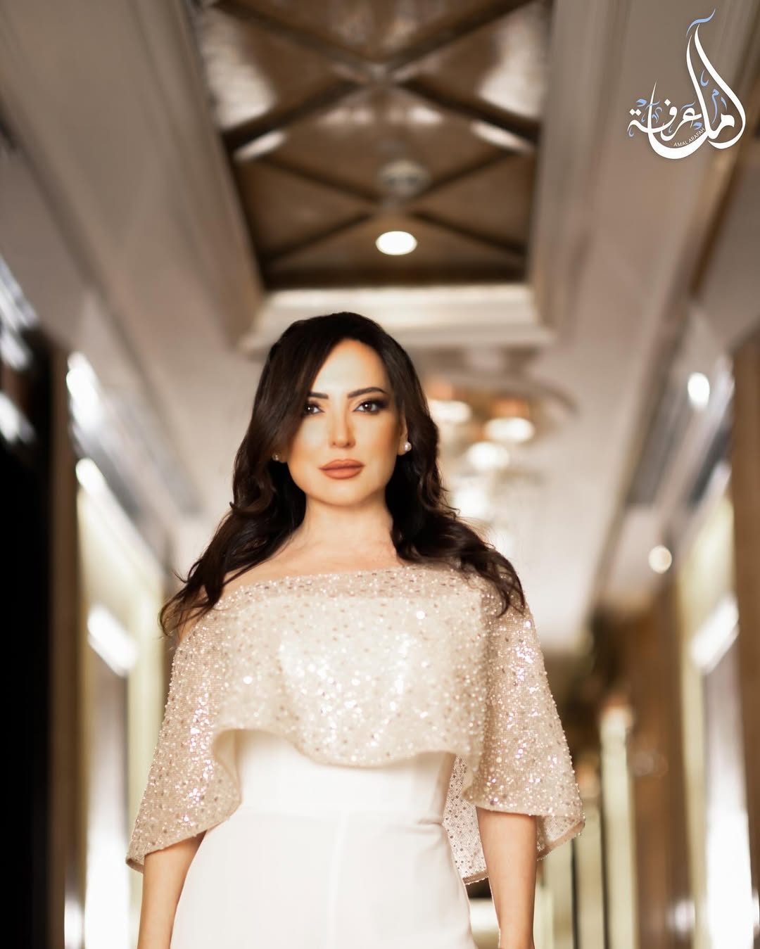 أمل عرفة بجمبسوت أبيض عصري