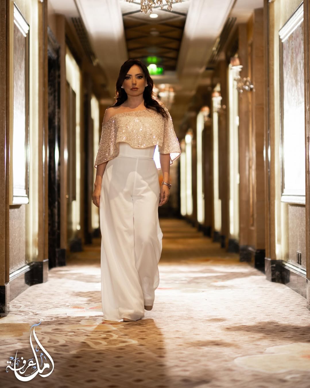 أمل عرفة بجمبسوت أبيض عصري