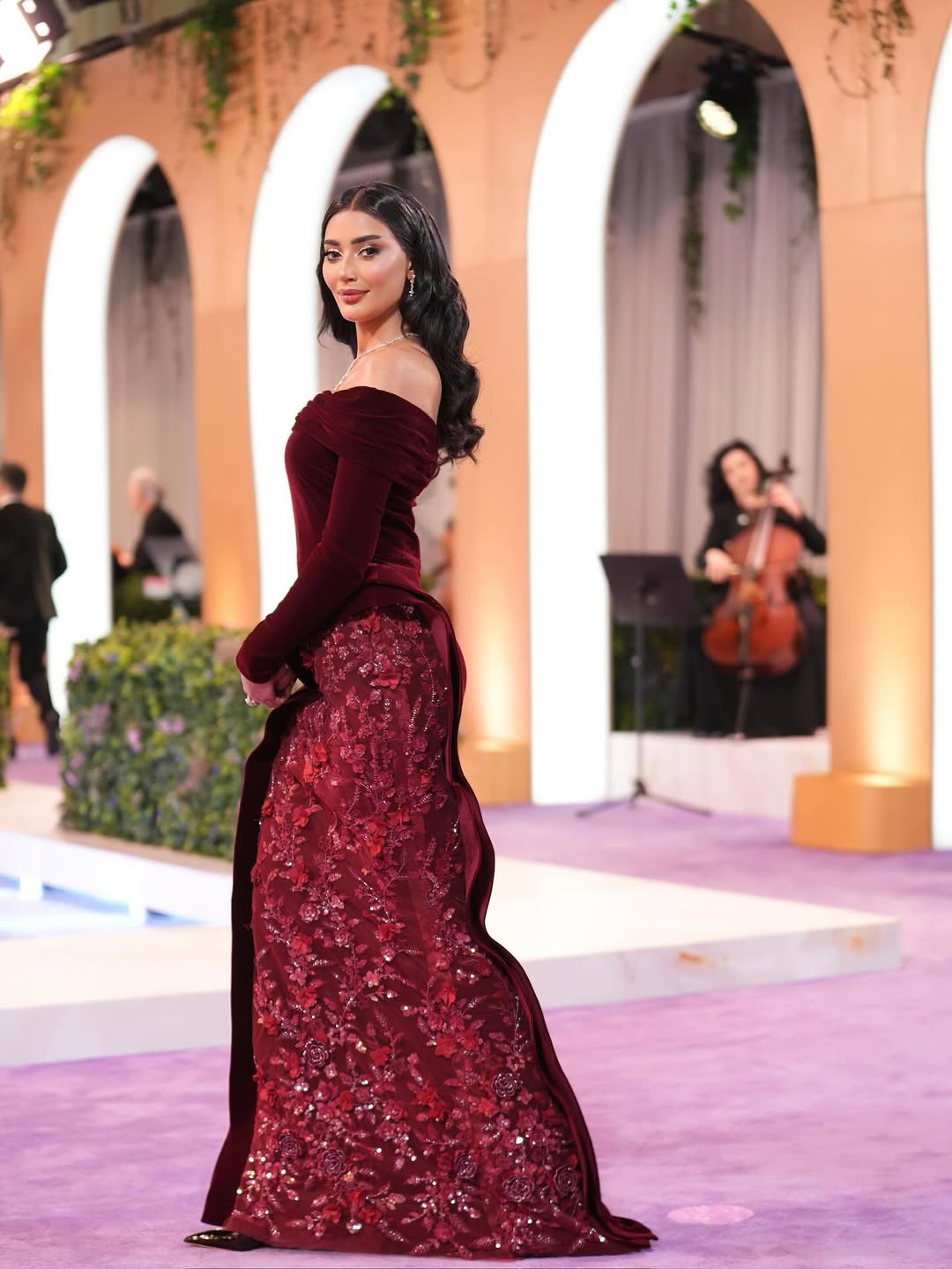 أميرة الشريف بالفستان البرغندي من المخمل بقصة الأوف شولدر 