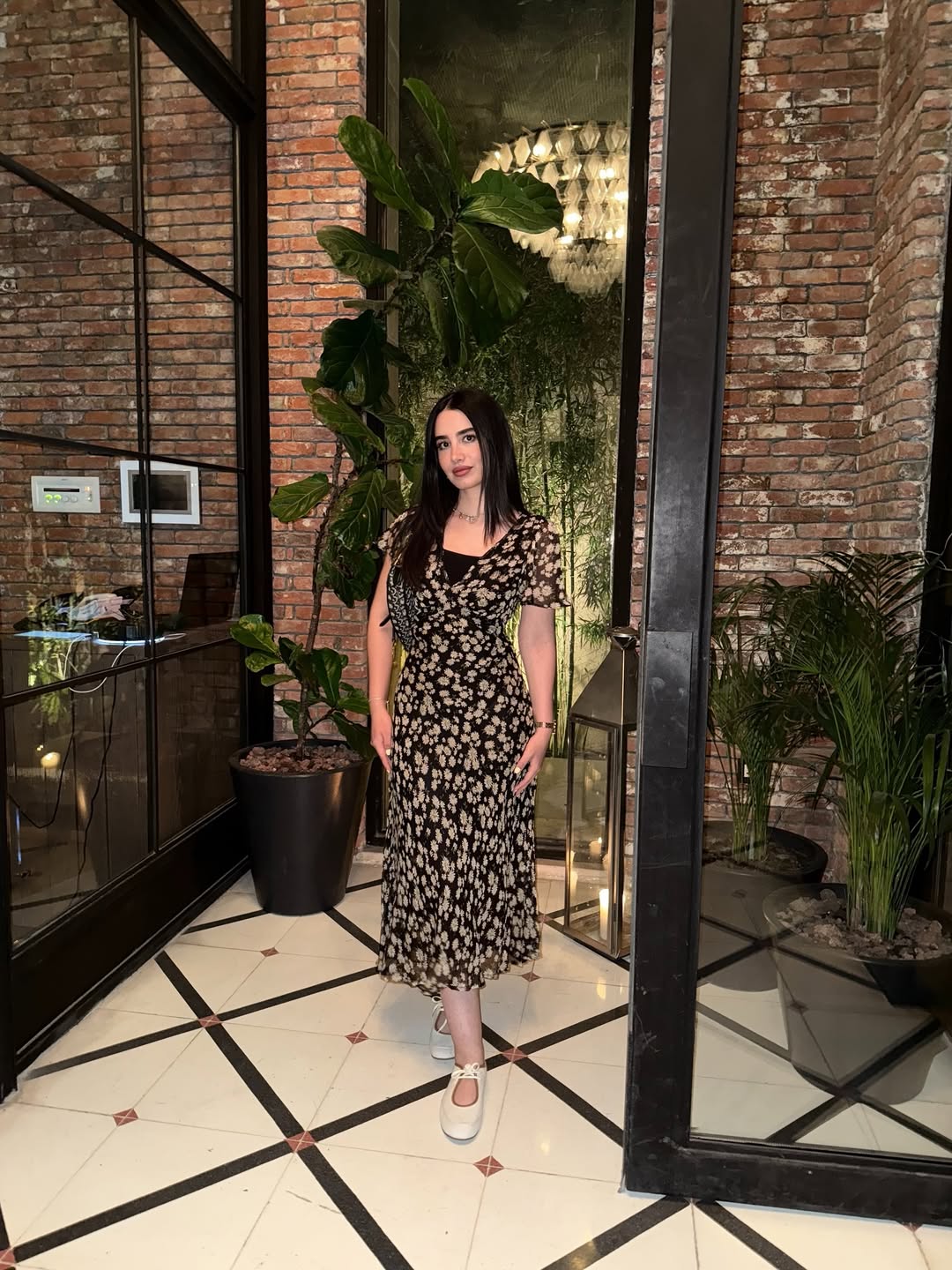 أميمة جواد الشكرجي بفستان ميدي باللون الأسود منقوش بالورود البيج