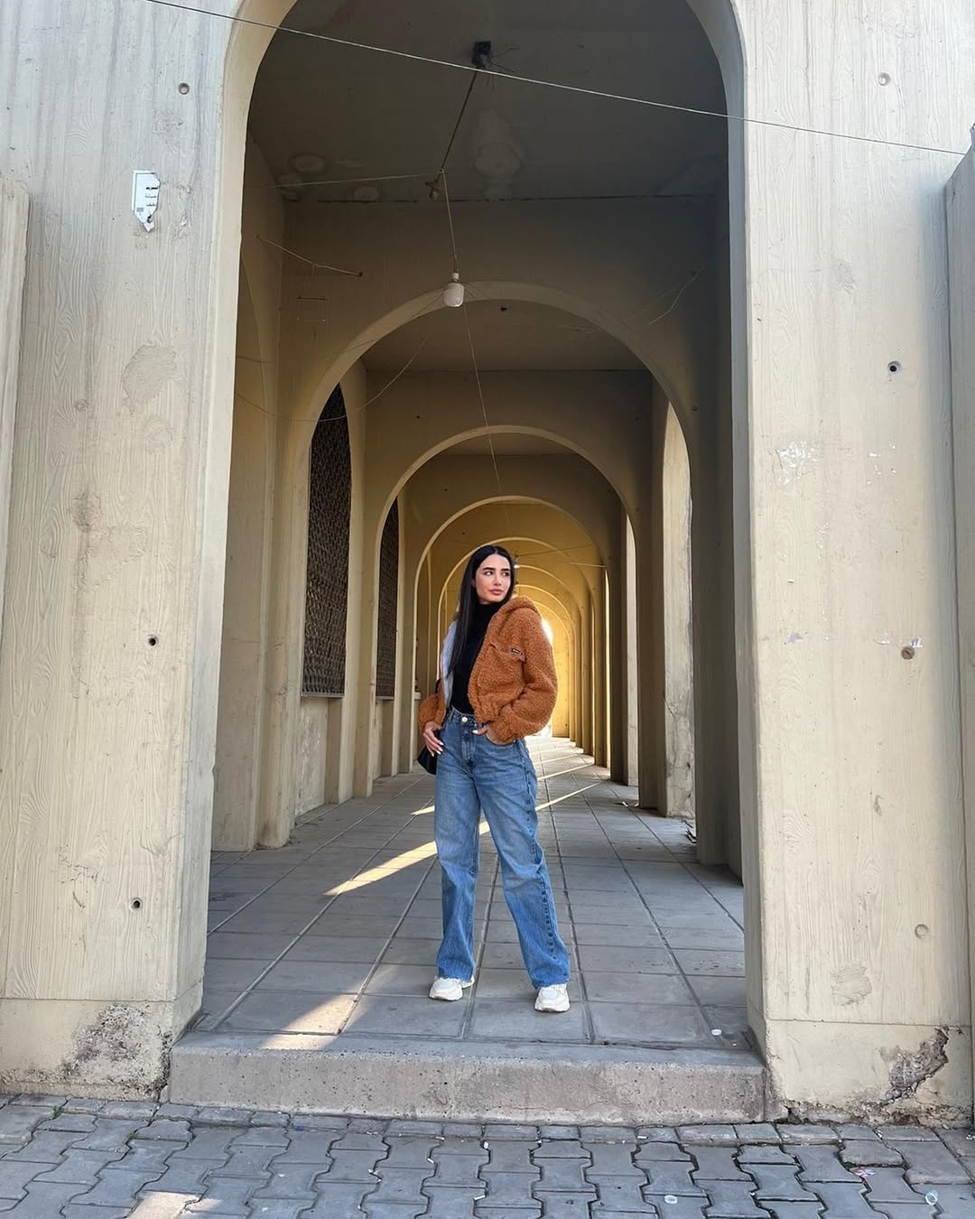  أميمة جوادب بنطال الجينز الواسع باللون الأزرق وتوب ضيق باللون الأسود