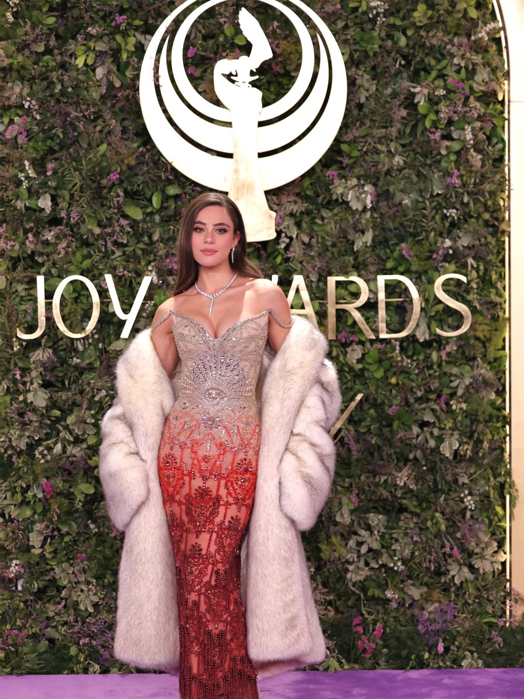 أندريا طايع بفستان مرصع بتطريزات كريستالية بسلاسة من اللون الفضي إلى اللون الأحمر