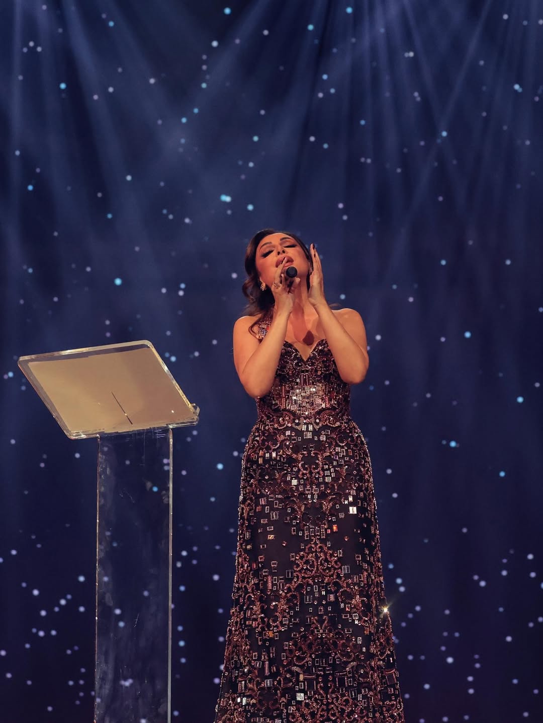 أنغام بفستان طويل بقصة سترابلس بلمسة ملكية بالكاب المنتفخ