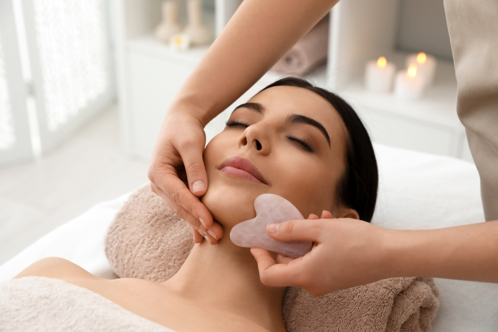 العناية المنزلية مثل أدوات Gua Sha تدعم تأثير الكونتور غير المرئي