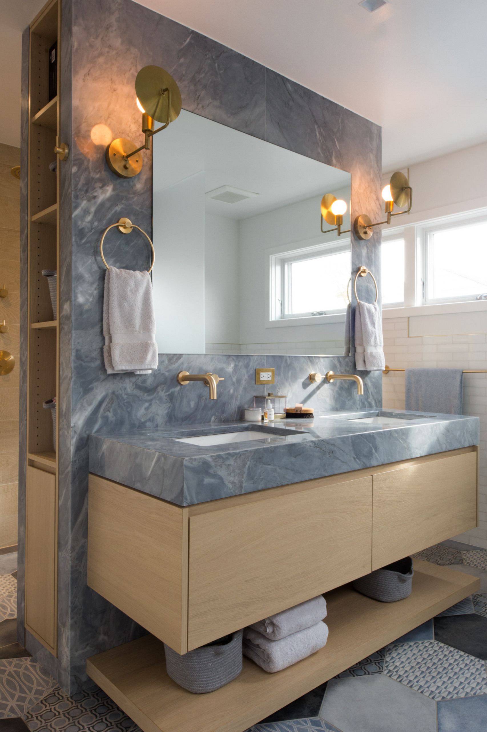 اللون الرمادي لأسطح العمل يمنح الحمام إحساسًا أنيقًا يشبه أجواء السبا