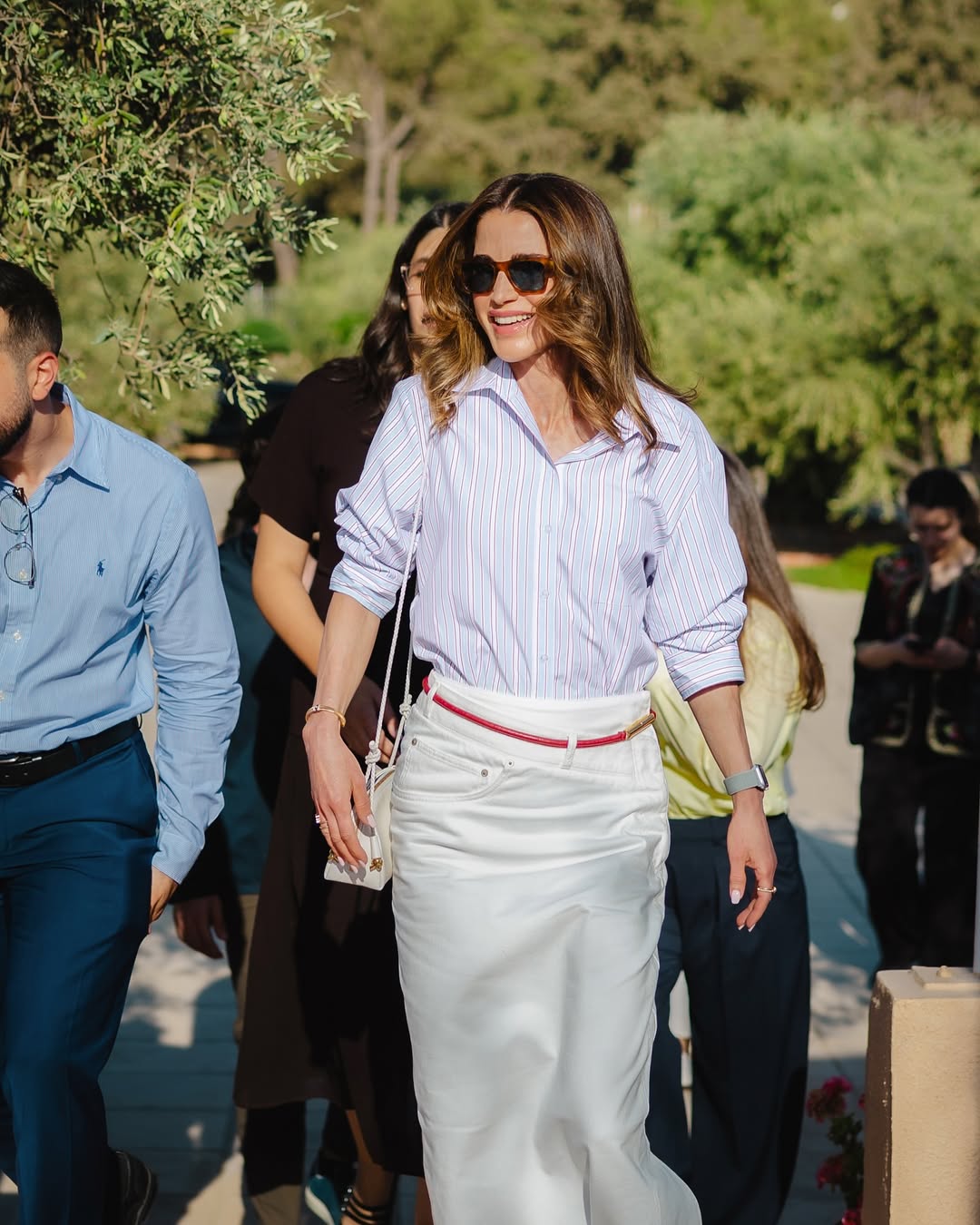 الملكة رانيا بالتنورة البيضاء مع قميص باللون الأزرق الفاتح المقلم