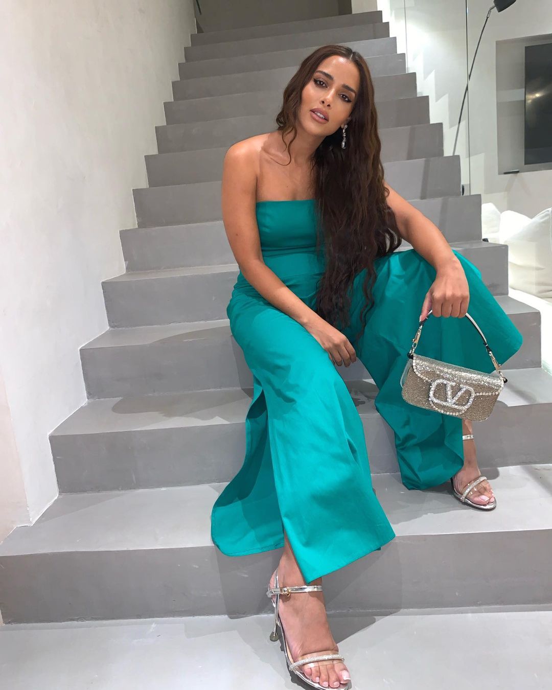 بلقيس بالجمبسوت الأزرق مع حقيبة لوكو Loco من Valentino Garavani باللون الفضيّ