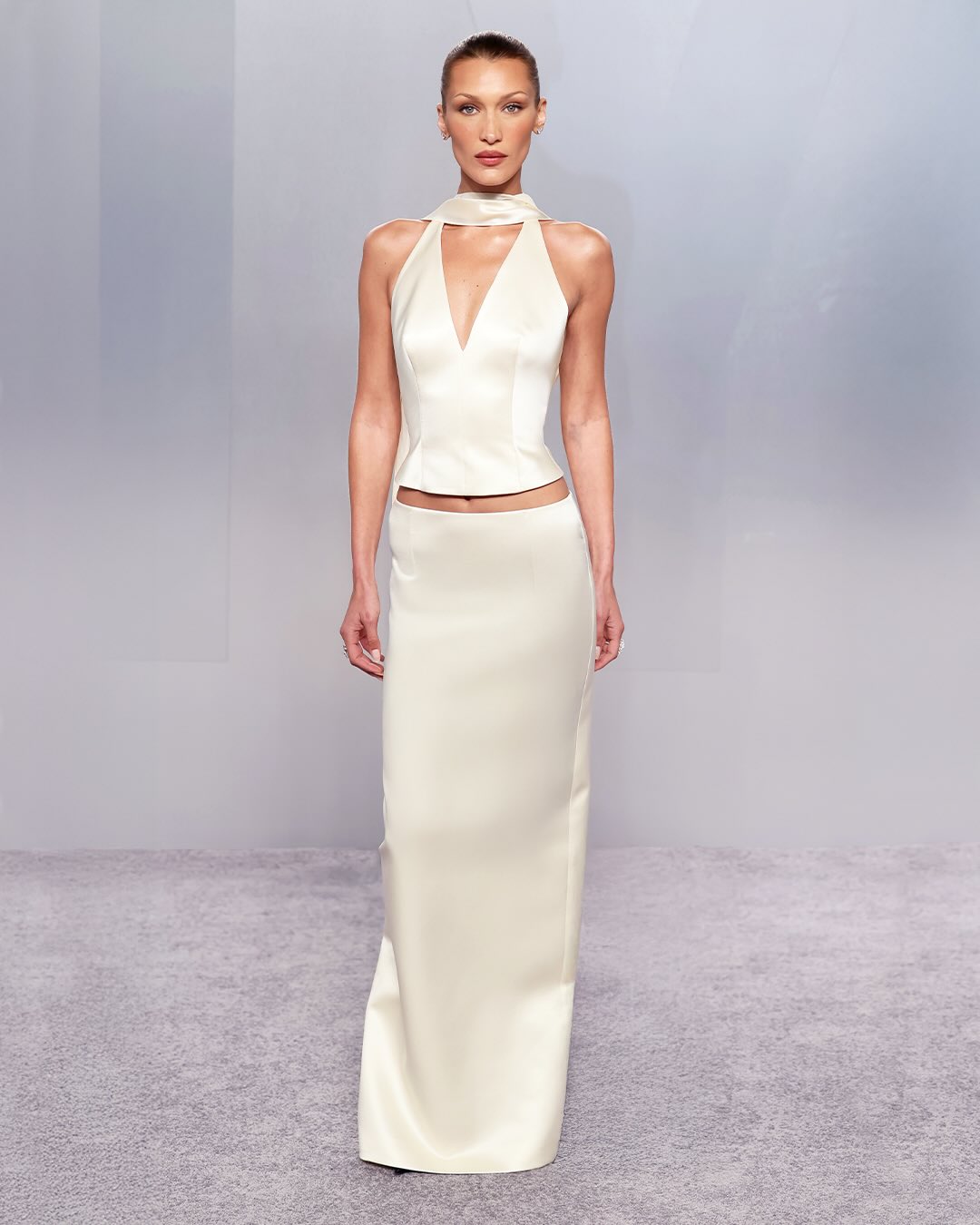  بيلا حديد بتنورة بنسل طويلة مع توب بفتحة ياقة الهالتر