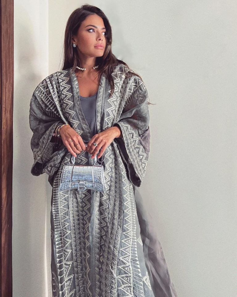تألقت العنود بالعباية الرمادية الواسعة المزيّنة بالتطريز ونسّقت معها الحقيبة الفضية