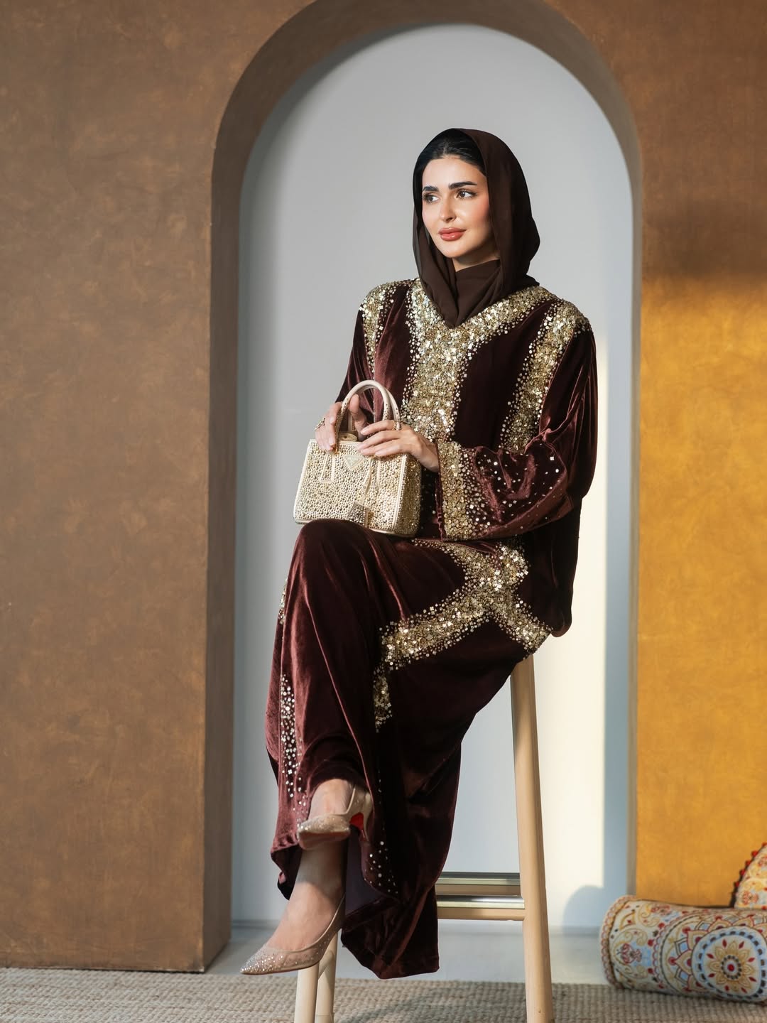 حنين الصيفي بعباية من المخمل باللون البني بتطريزات من الترتر الذهبي