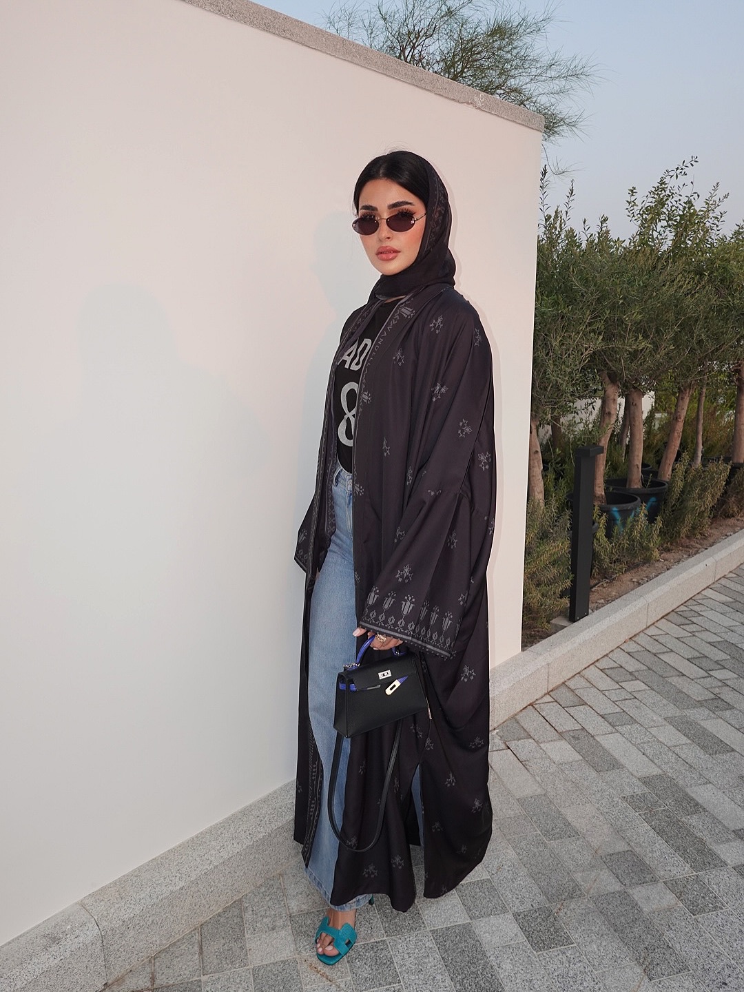 حنين ببنطال الجينز الواسع  وعباية سوداء مطبوعة بنقوشات شرقية