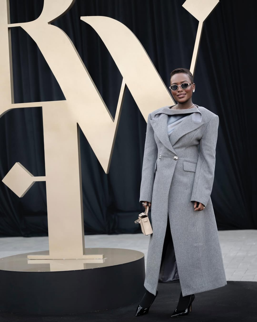 خديجة معاذ بالمعطف الصوفي الطويل باللون الرمادي