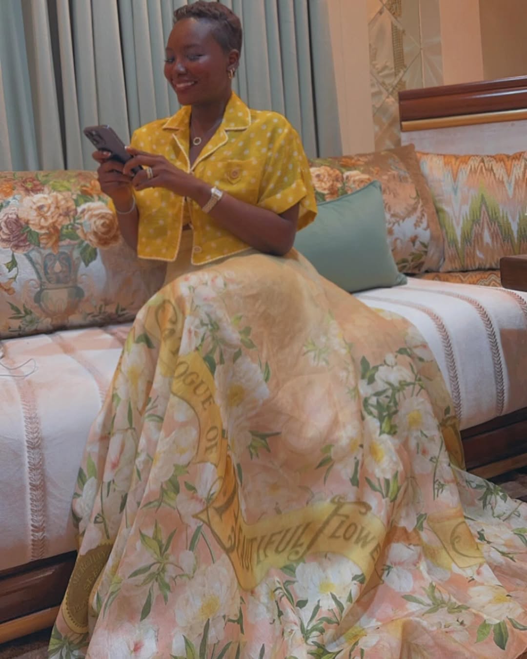 خديجة معاذ بتنورة ماكسي بلون نيود مطبوع بالورود وقميص أصفر بنقاط البولكا البيضاء