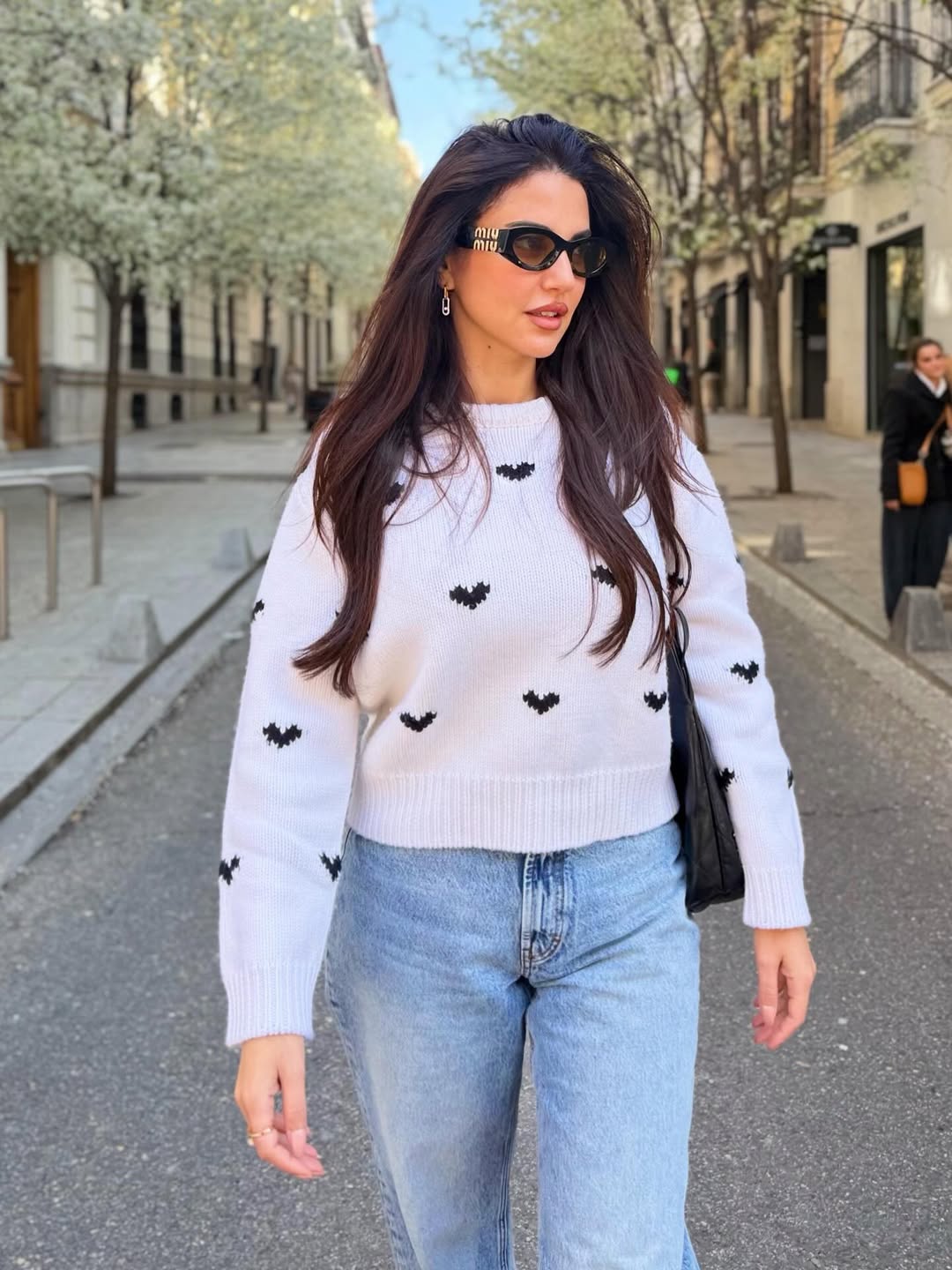 درة ببنطال شاحب وبلوفر أبيض محبوك بغرز القلوب المتناثرة 