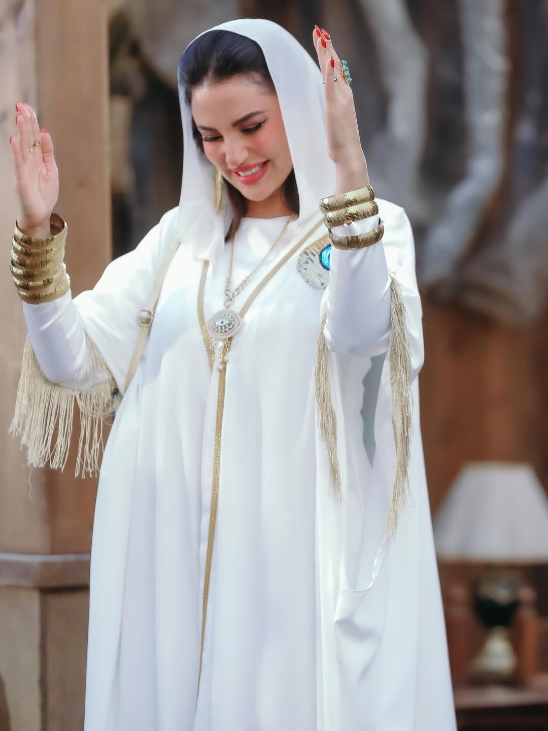 درة بعباية فضفاضة باللون الأبيض موصولة بغطاء الرأس