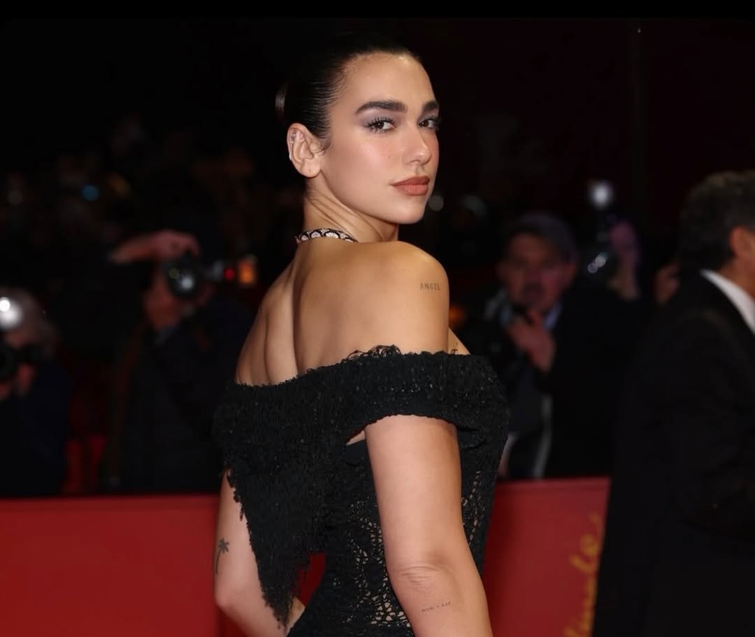 دوا ليبا ترتدي فستانا طويلا باللون الأسود محبوك بغرز مفتوحة