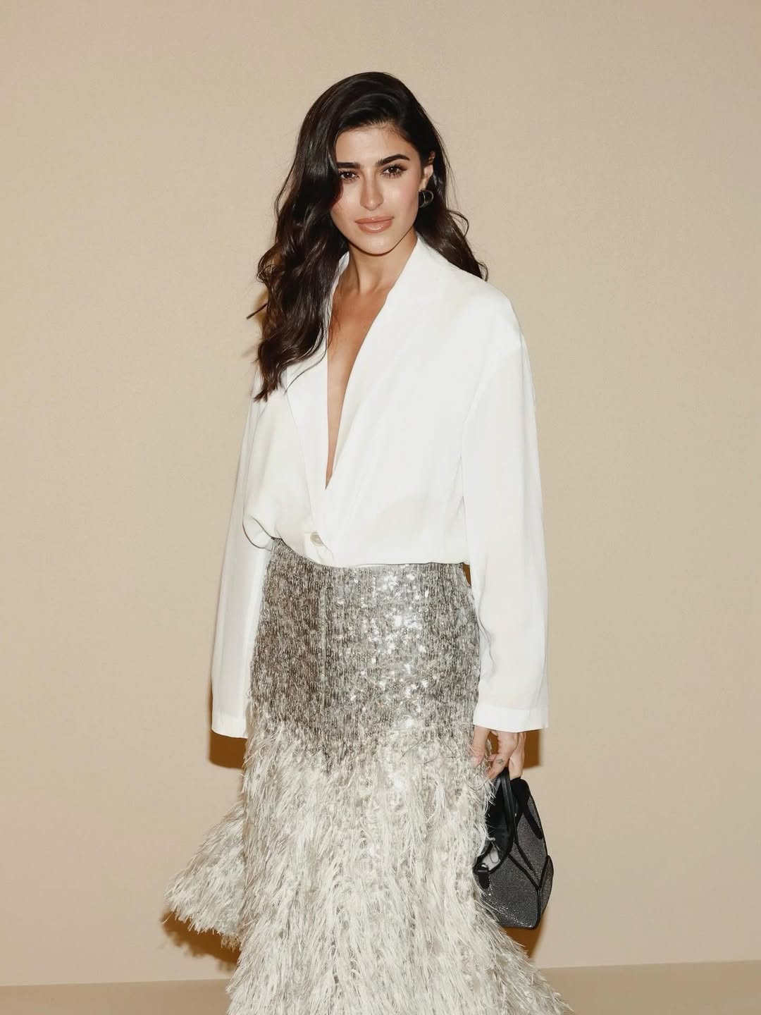 ديما الشيخلي بتنورة بقصة ميدي منتفخة بأطراف يكسوها الريش الأبيض