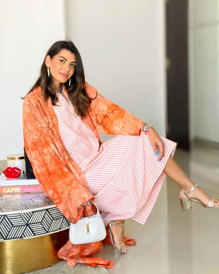 دينا زهران تألقت بالقفطان باللون البرتقالي وجمعت بإطلالتها بين نقشة المقلّم والتاي داي