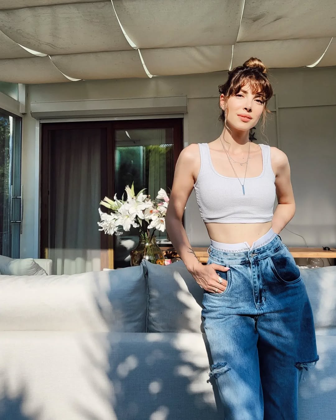 دينيز بايسال ببنطال الجينز الواسع مع كروب توب باللون الأبيض