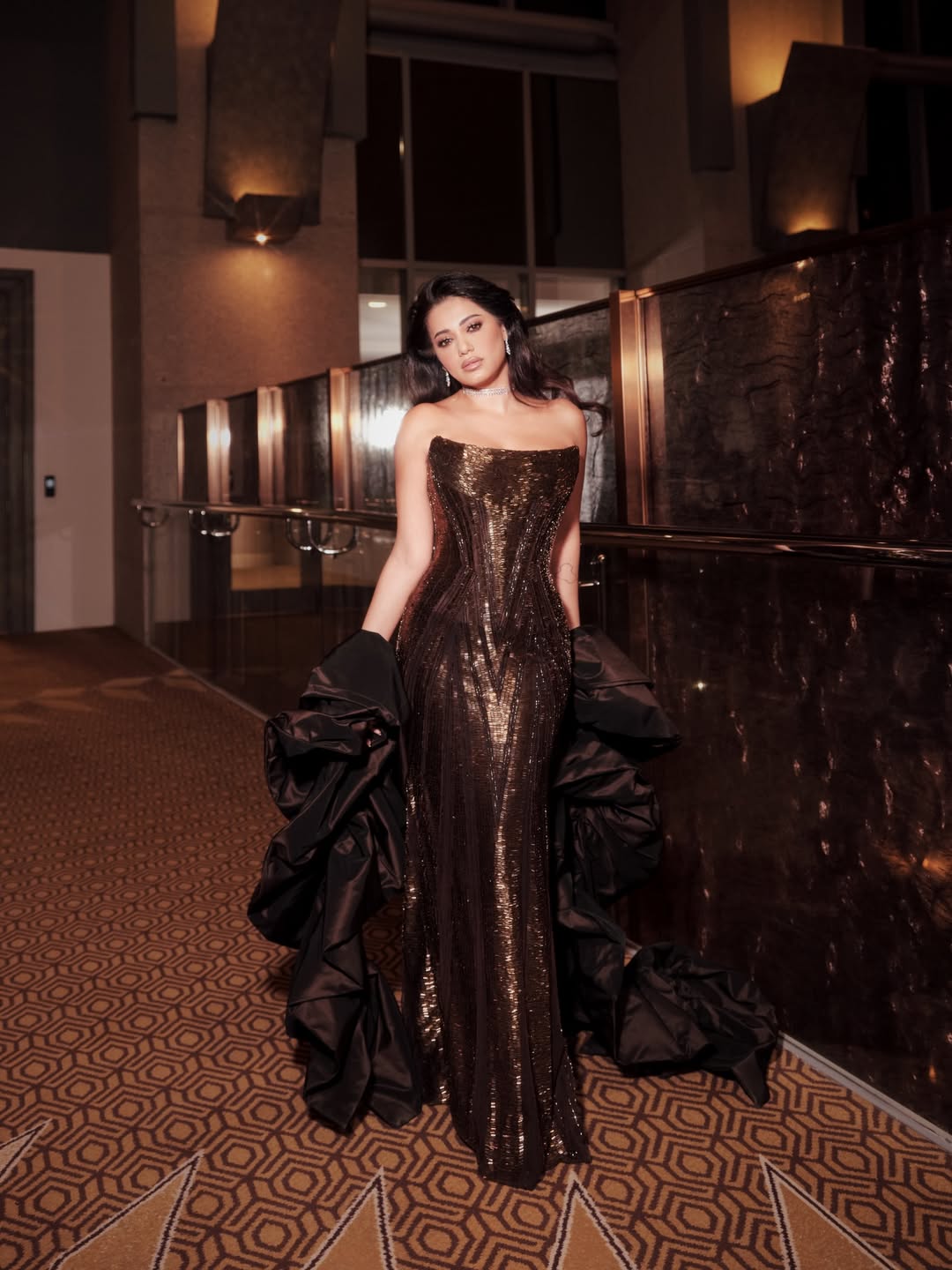 رحمة رياض بفستان مرصع بالخرز باللون البني مرفقا بكاب دراماتيكي