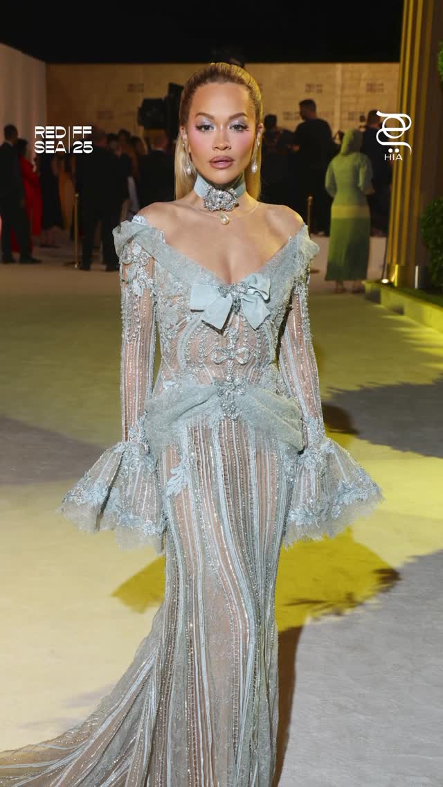 ريتا أورا بفستان طويل محدد لمعالم قوامها بقماش شفاف باللون الأزرق الشاحب