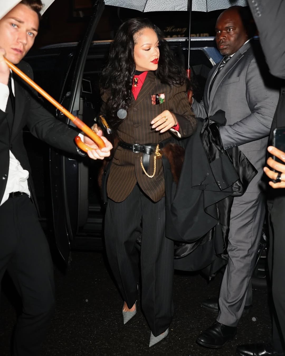 ريهانا بنطال مقلم وواسع باللون الأسود مع جاكيت بني مزين