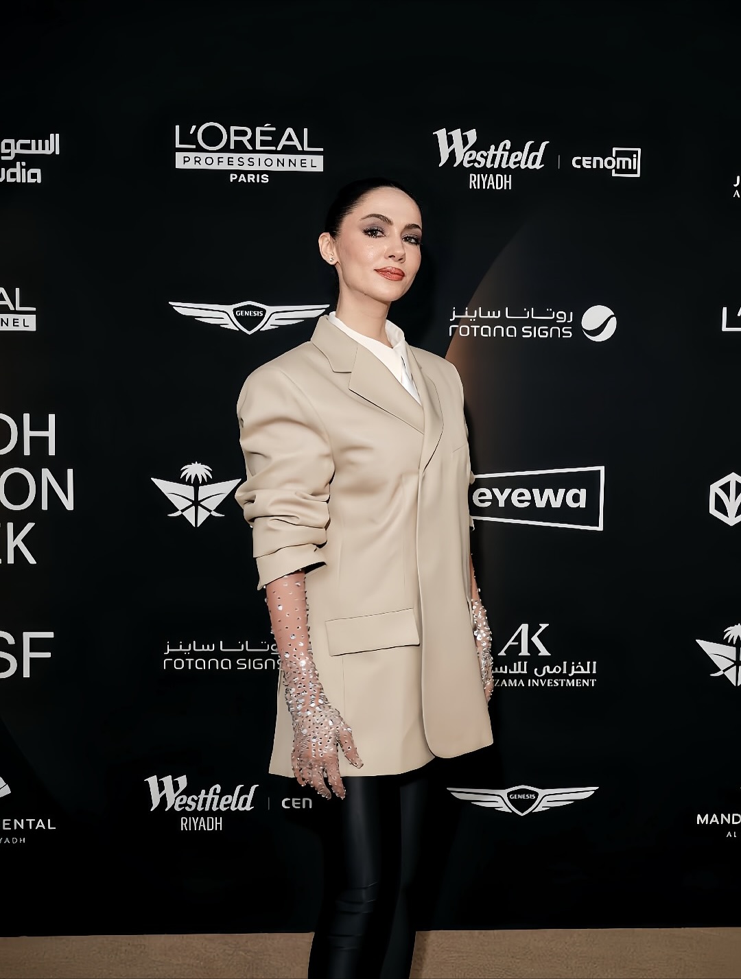 سمية رضا ببليزر باللون البيج، بأكمام مرفوعة بلمسة مشعة بارتداء قفاز عالي