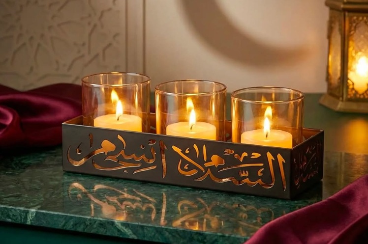 صينية للشموع مصنوعة من البرونز المطفي، تتخللها تفريغات دقيقة من الخط العربي