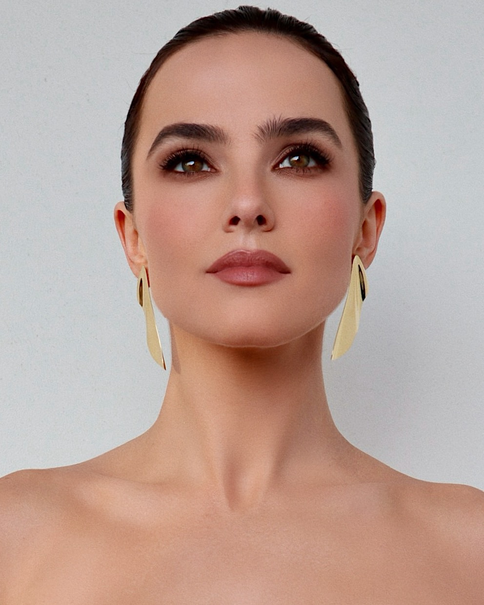 ظلال العيون الترابية مع الخطوط البنية العريضة بأسلوب Zoey Deutch
