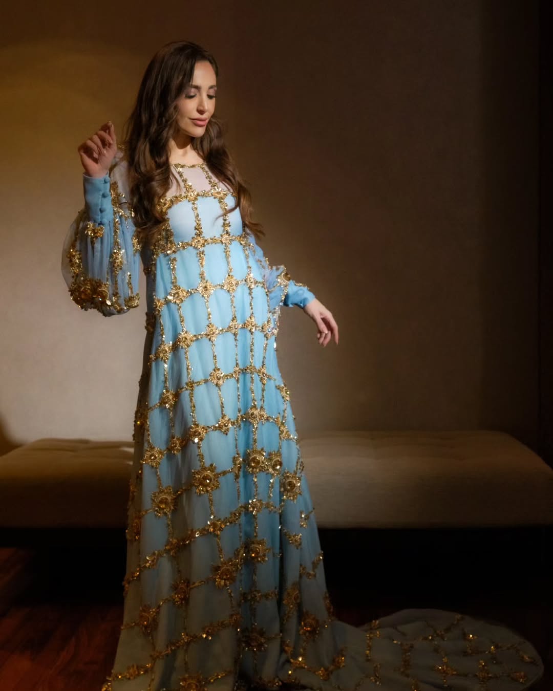 عبير بفستان طويل منسدل بالقصة الفضفاضة باللون الأزرق الفاتح