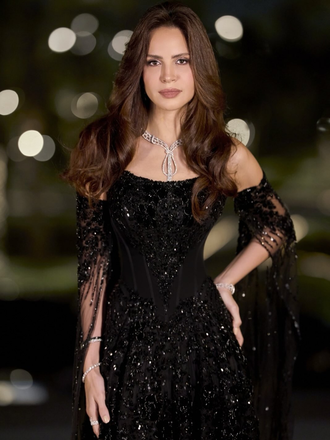 فستان آمال ماهر تميز بقصة مفتوحة ومتدلية على شكل أوشحة طويلة