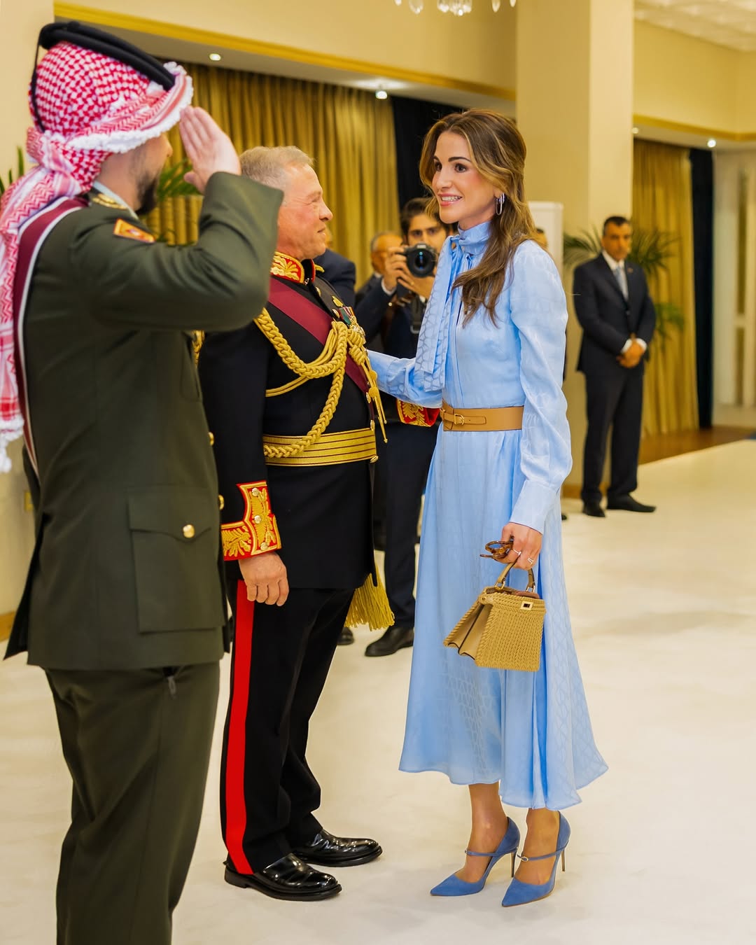 فستان الملكة رانيا مصمم بأكمام منتفخة وطويلة مع الياقة العالية المزينة بعقدة جانبية