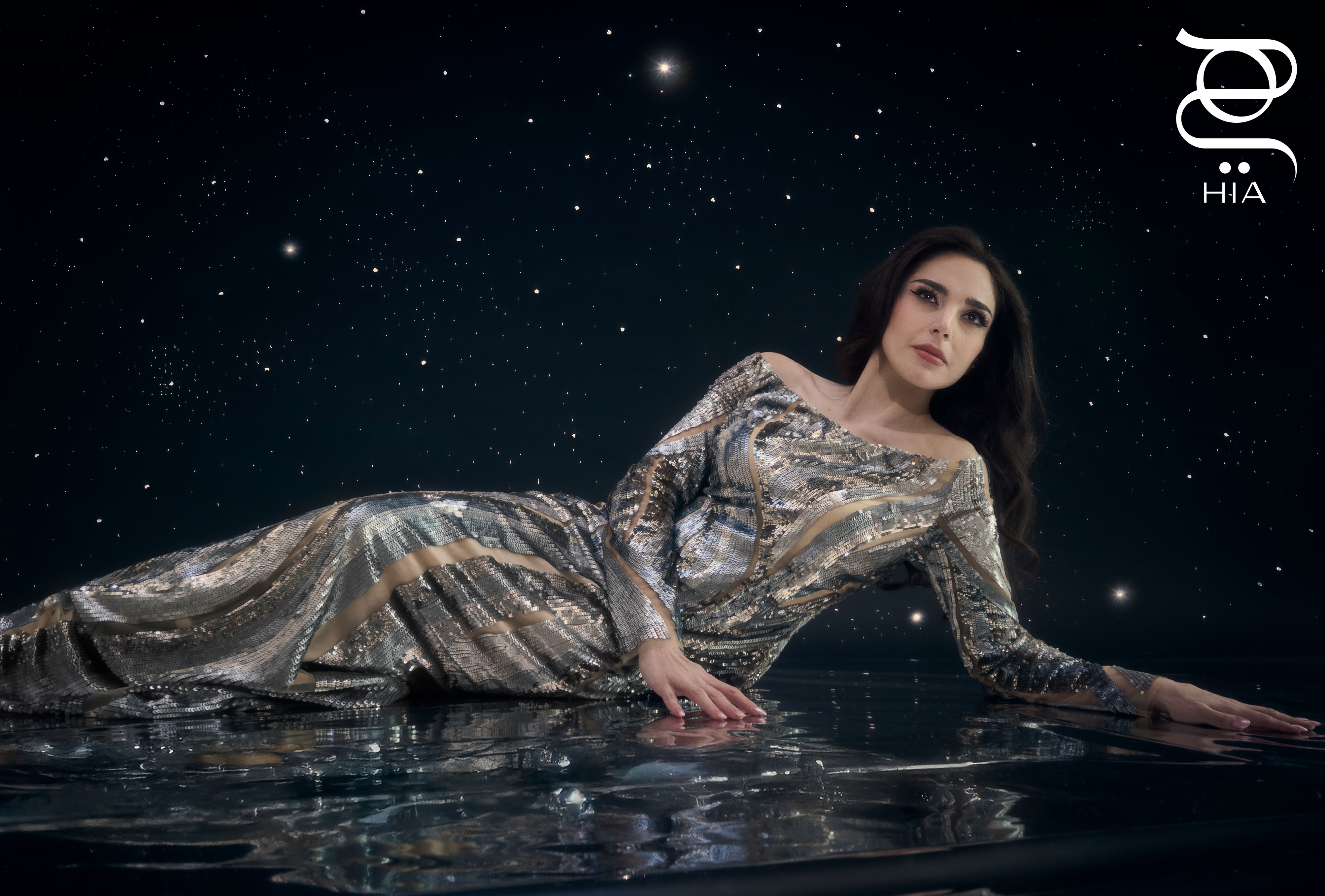 فستان طويل مُزيّن بالترتر باللون الفضي من مجموعة مارينا رينالدي وزهير مراد الكبسولية Marina Rinaldi by Zuhair Murad