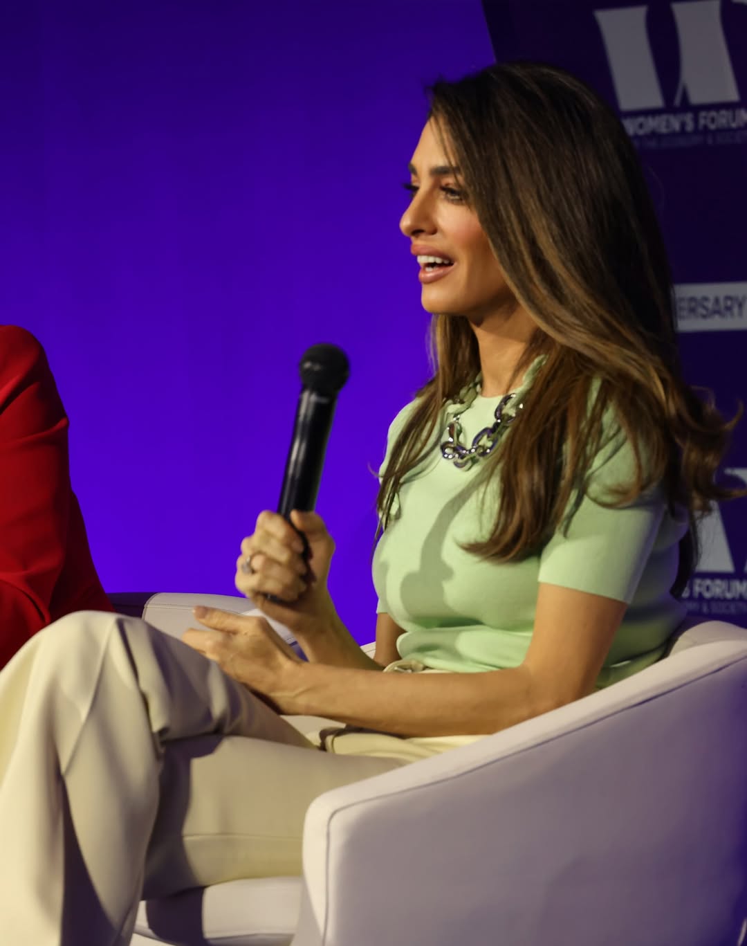 أمل كلوني ببنطال كلاسيكي عالي الخصر باللون البيج، مع توب باللون الأخضر الباستيل