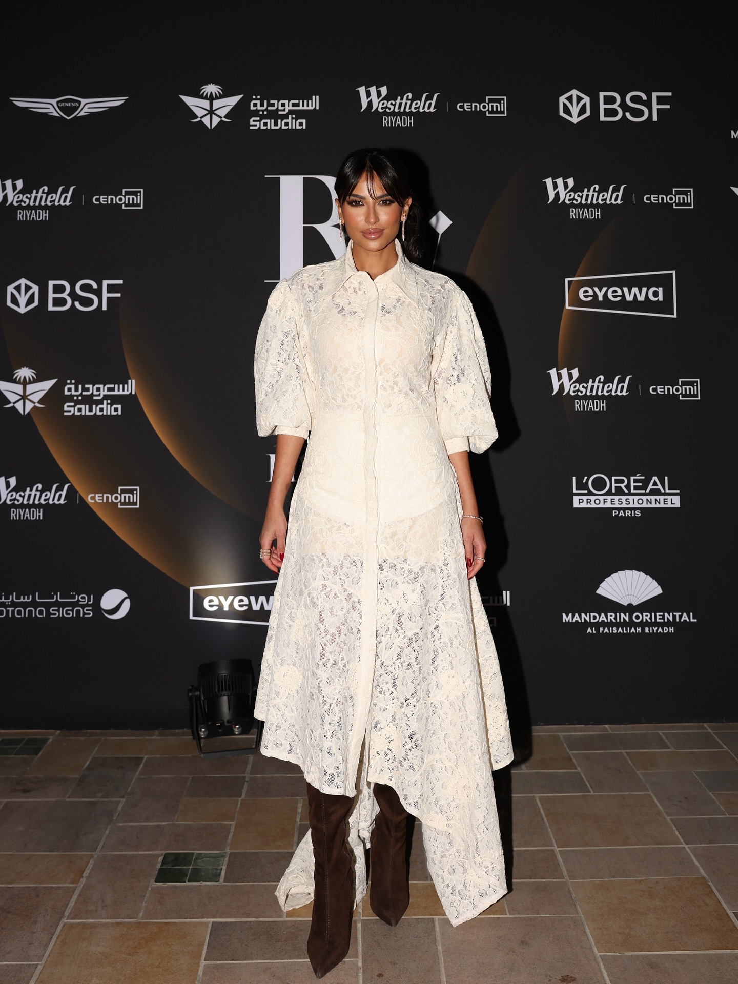 لما العقيل بفستان طويل من الدانتيل الأبيض