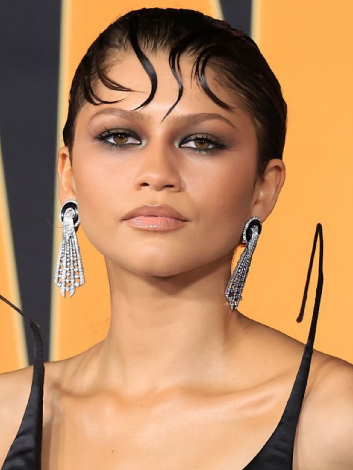 مكياج عيون مشرق بالظلال البنبة والذهبية مع الخصل الامامية على الجبين بأسلوب Zendaya