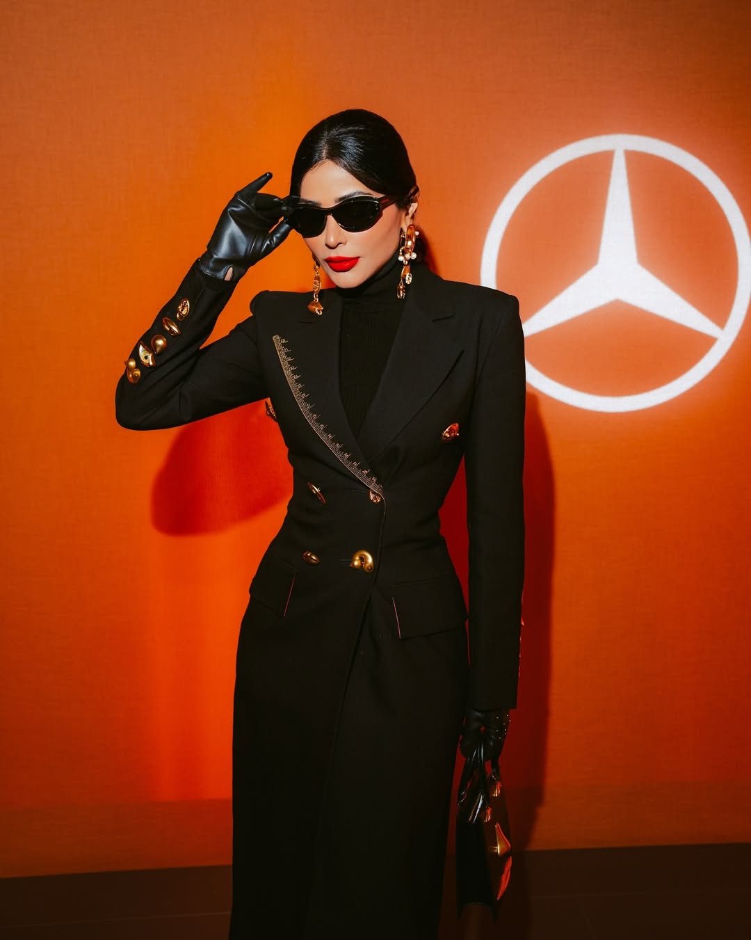 مهيرة عبد العزيز بفستان طويل بقصة المعطف مع القفاز القصير من الجلد الأسود