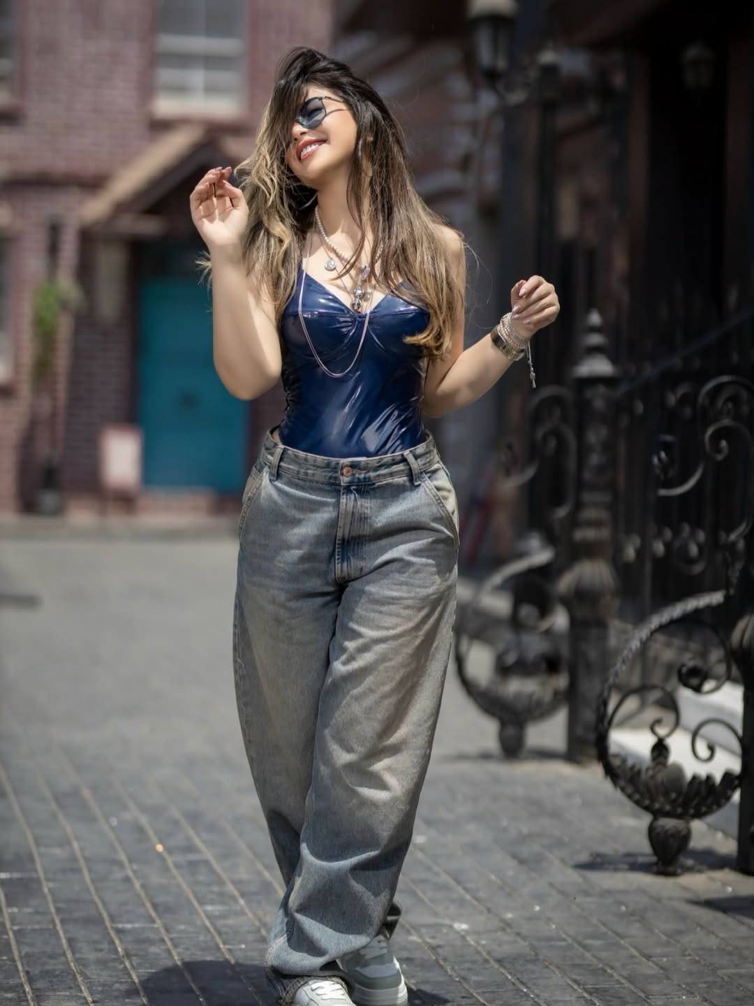 ميرنا جميل بنطال الجينز الشاحب بالأرجل الواسعة مع توب ضيق من الجلد باللون الأزرق الداكن،