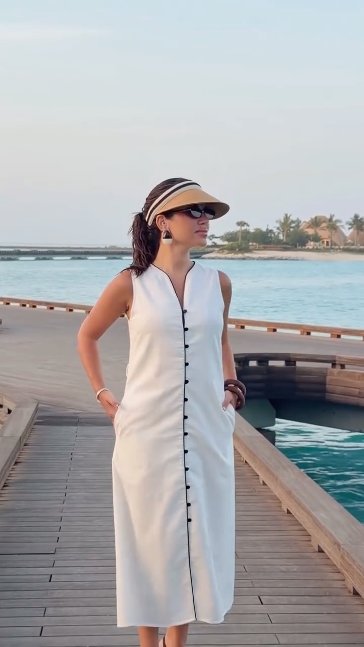 نجود الرميحي بفستان مستقيم طويل باللون الأبيض مع الأزرار السوداء