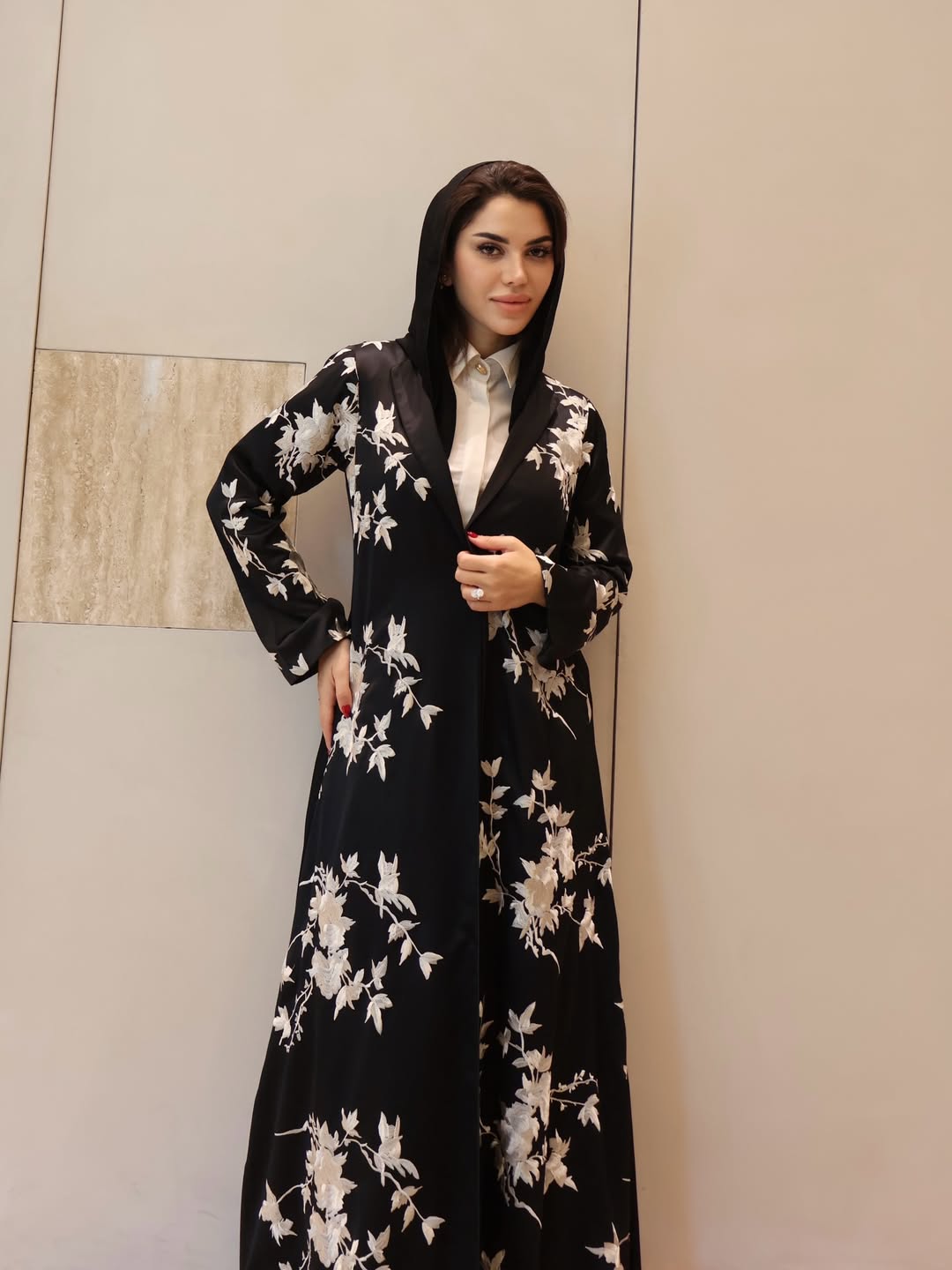 نجود عباية أخرى باللون الأسود، مزينة بنقوشات الورود البيضاء ا