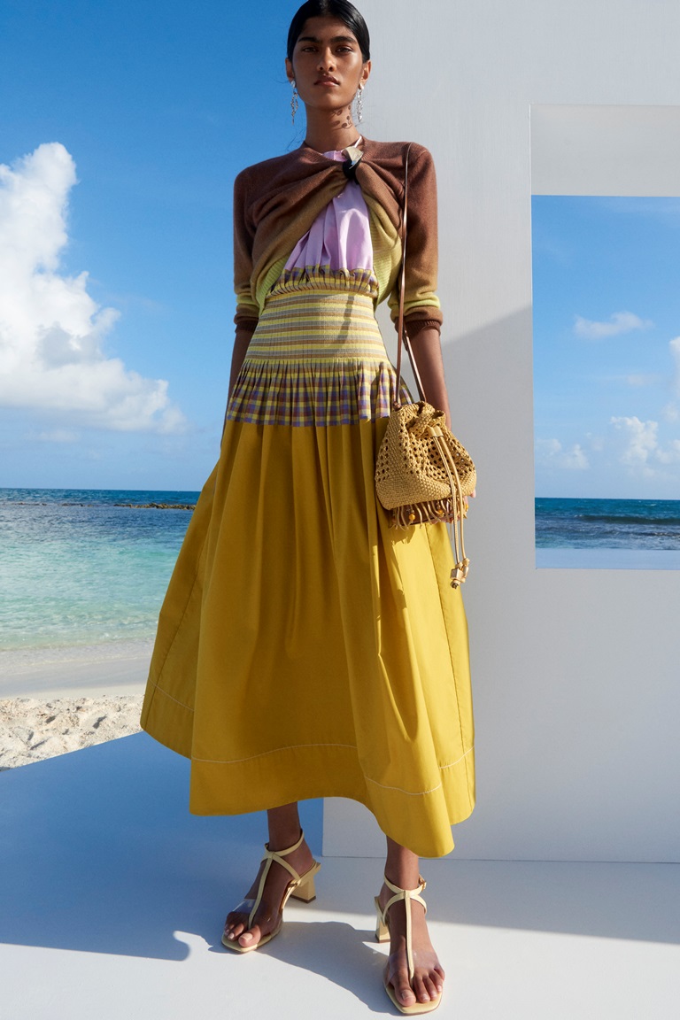 نسقي التنورة الصفراء من Tory Burch مع درجات اللون البني والأبيض