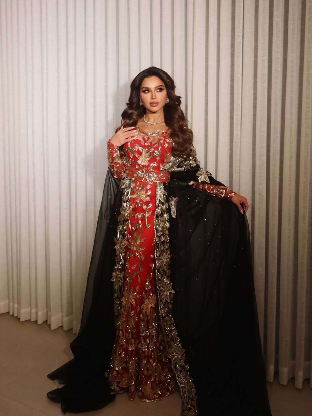 نهى نبيل بإطلالة على شكل ثوب مجسم باللون الأحمر مميز بأكمام طويلة