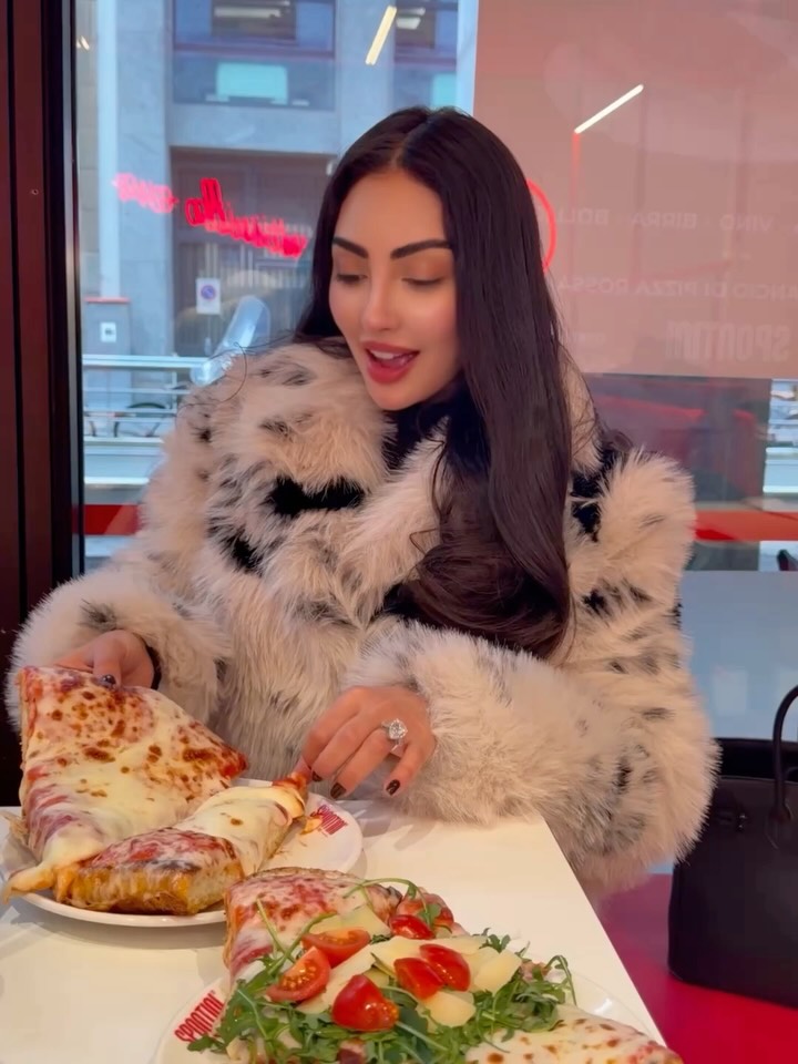 نور الغندور تتناول قطعا من البيتزا 