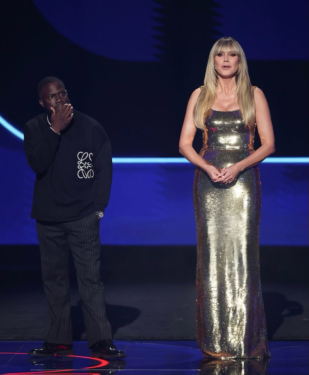 هايدي كلوم ترتدي فستانا طويلا بقماش انسيابي مرصع كليا بالترتر الذهبي