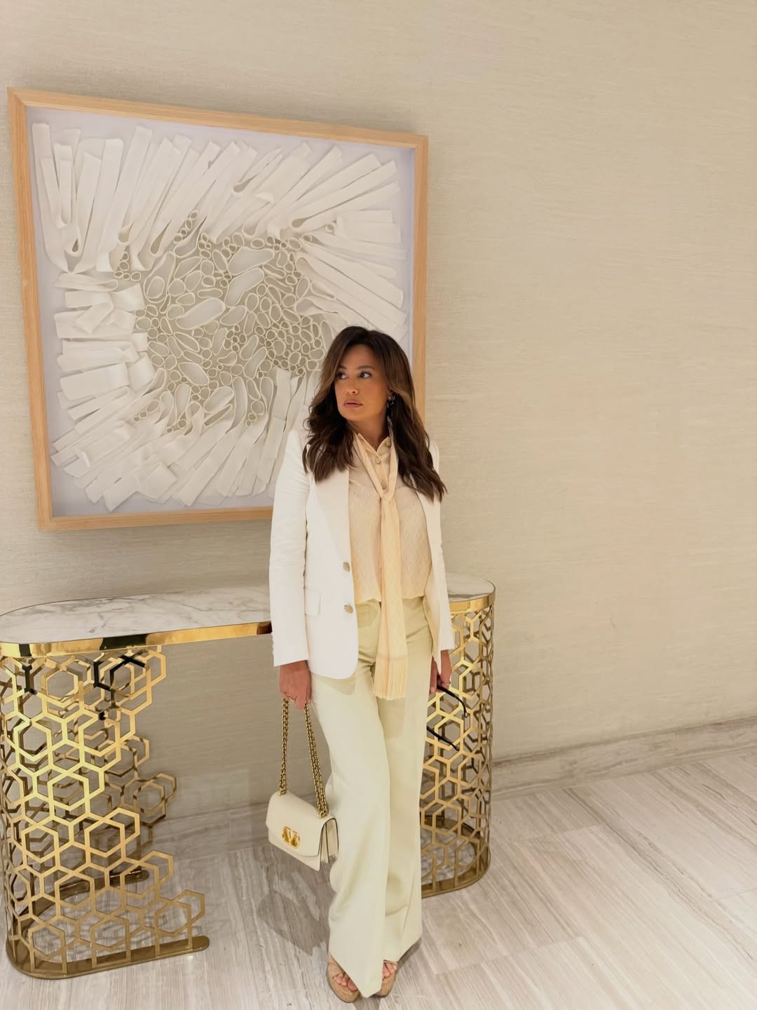 هند صبري ببنطالا واسعا باللون البيج مع قميص حريري رقيق بلون كريم